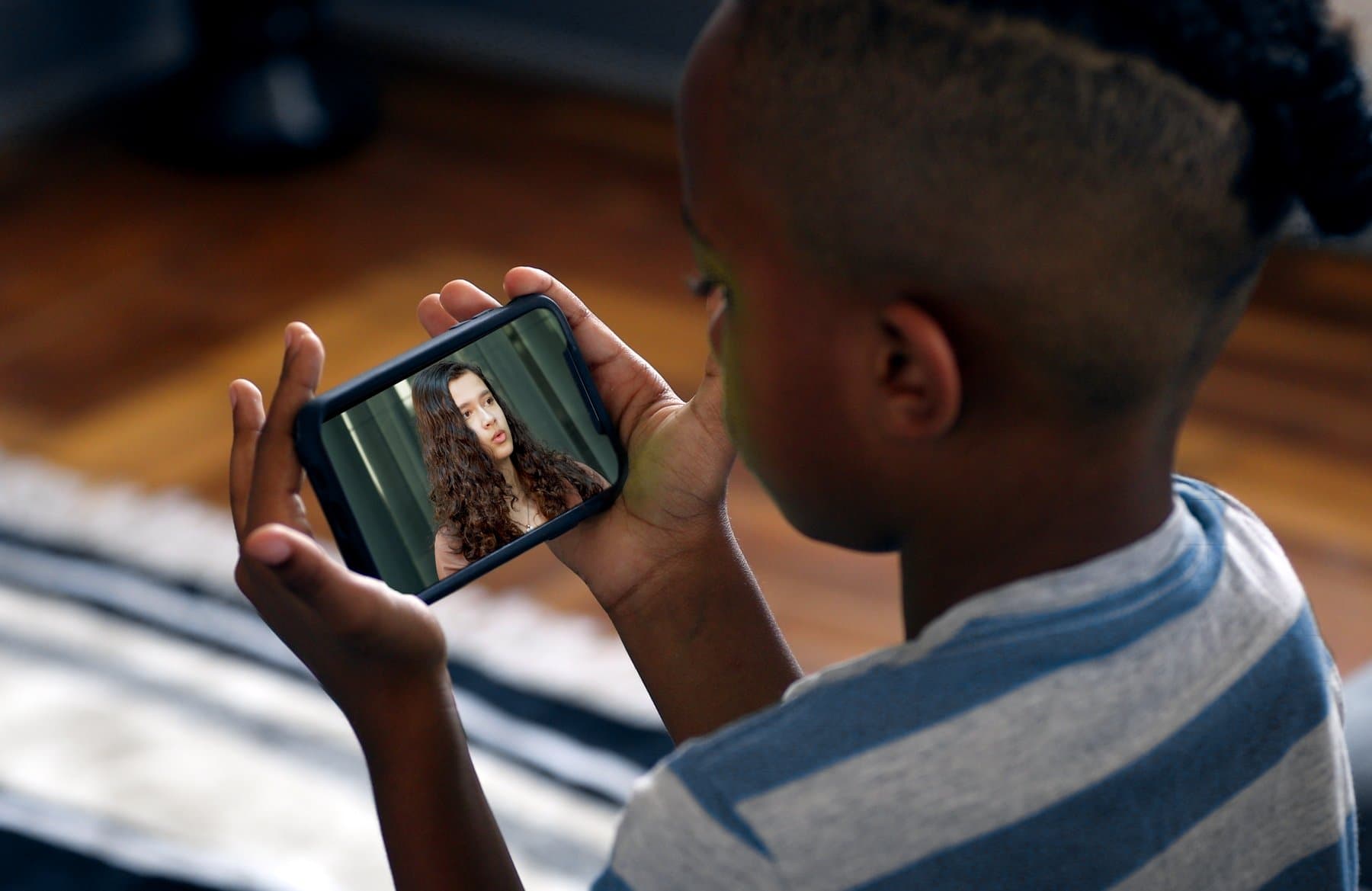 A young person watches a peer story on a phone.